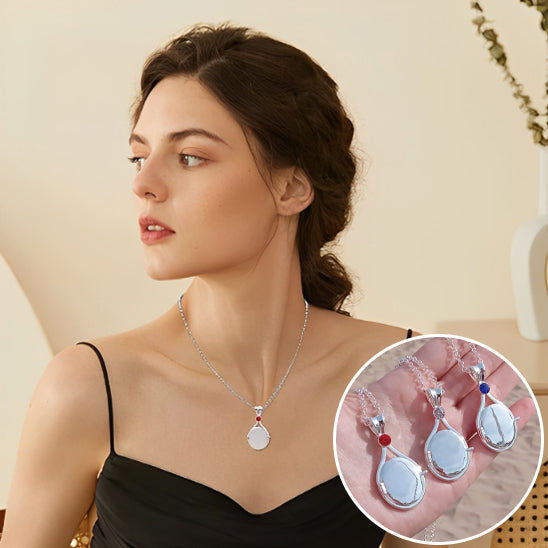 Woman wearing a silver necklace with a close-up inset of the pendant.