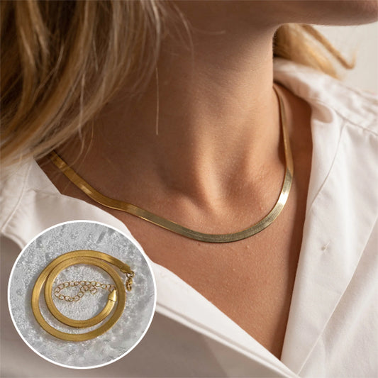 Gold necklace worn by a person with an inset showing the necklace on a white surface.